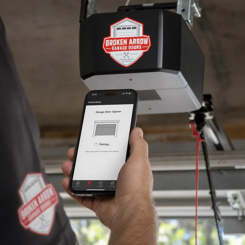 Contractor pairing a smartphone garage door app near the installed opener